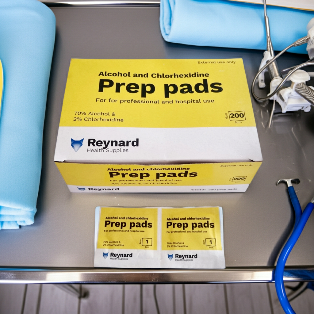 Box of Alcohol and Chlorhexidine Prep pads on a metal surface with towels and a stethoscope.