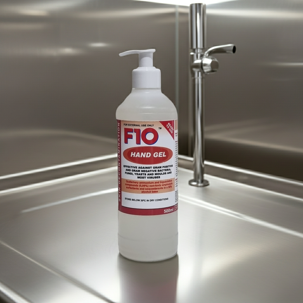 F10 hand gel bottle on a stainless steel surface with a tap in the background