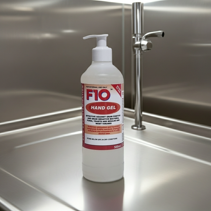 F10 hand gel bottle on a stainless steel surface with a tap in the background