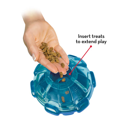 KONG Rewards Ball with hand and  treats being added to it on a white background.