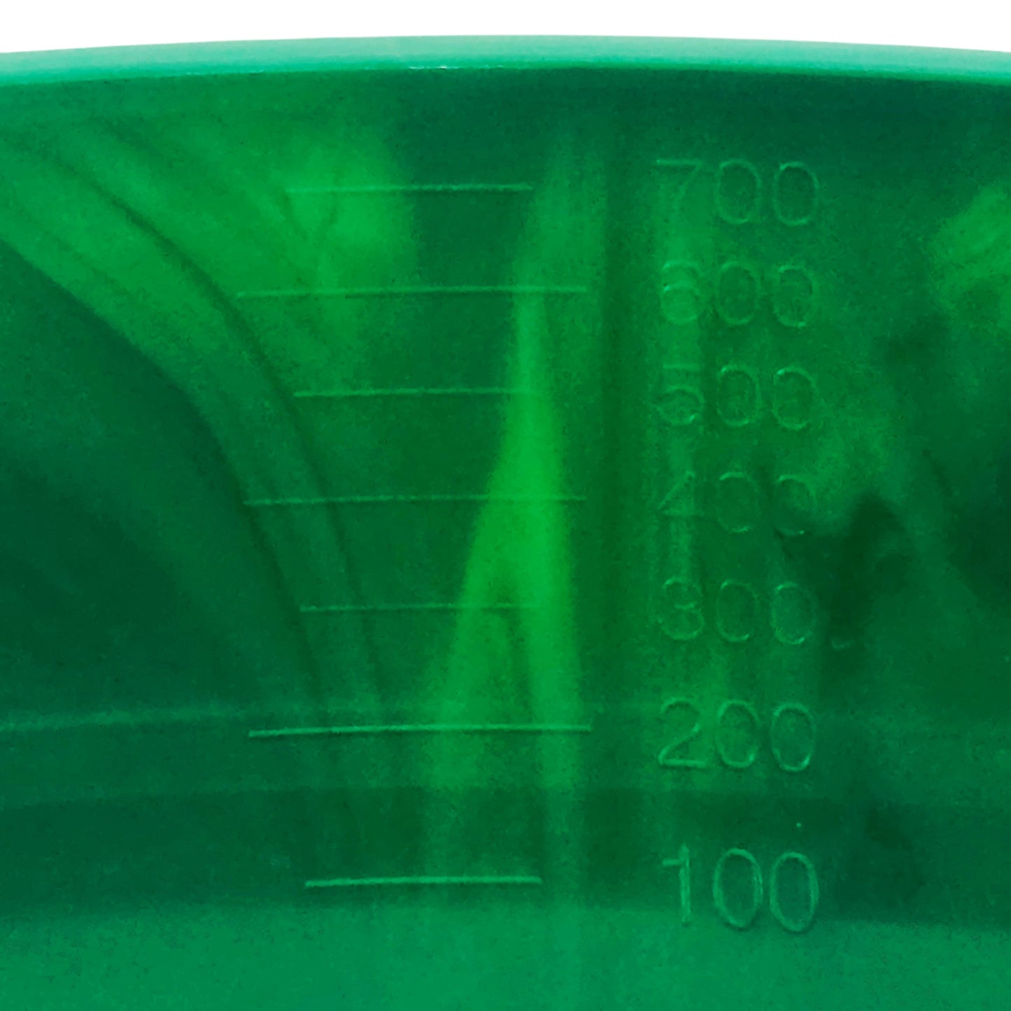 Close-up of a green plastic kidney dish with measurement markings