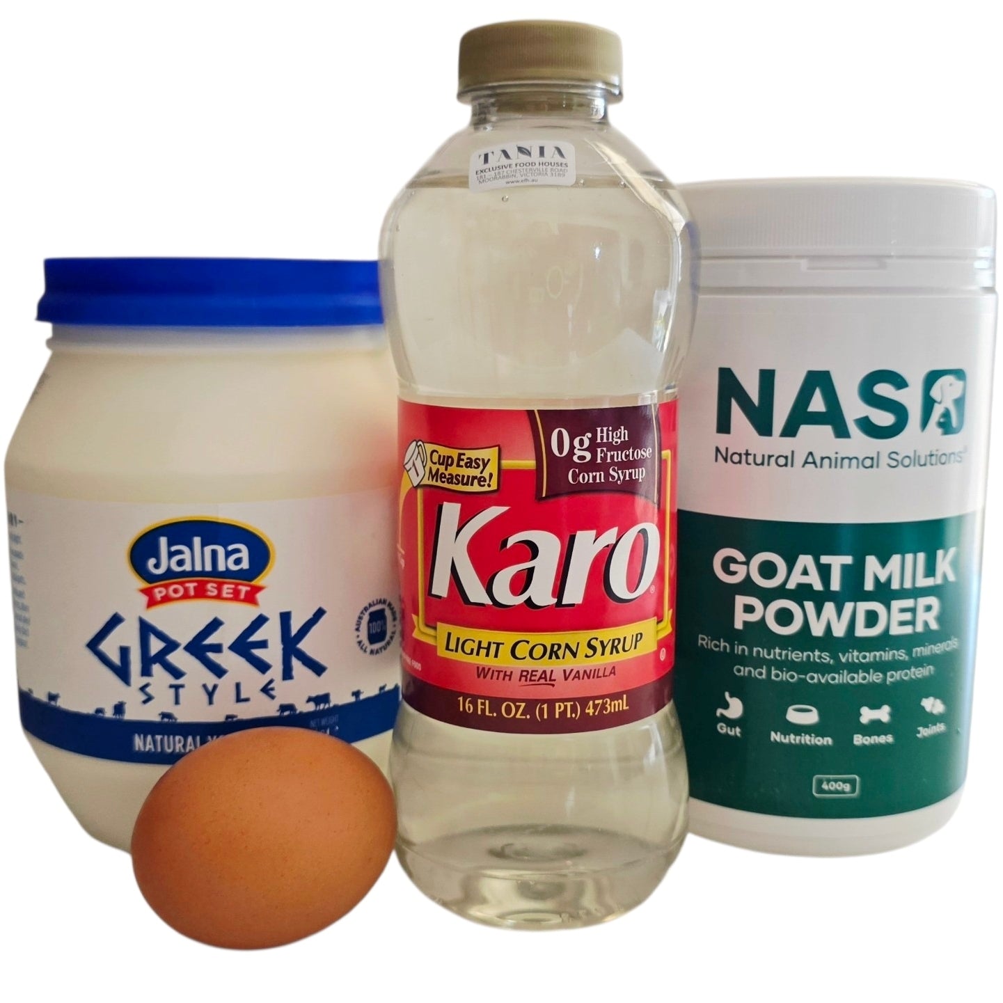Jalna Greek Style yogurt, Karo corn syrup, and NASO goat milk powder with an egg on a white background.