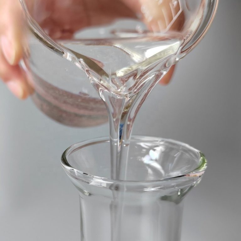Poring liquid paraffin from a beaker on a gray background