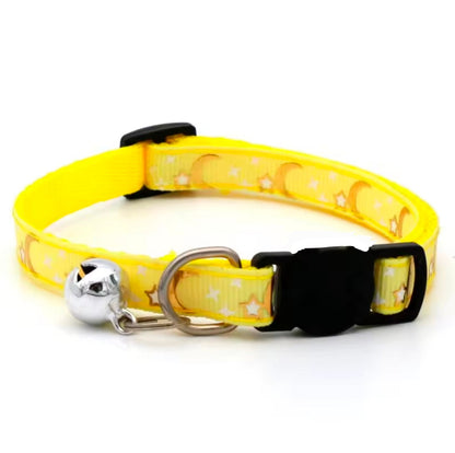 Yellow cat collar with black buckle and silver bell on a white background