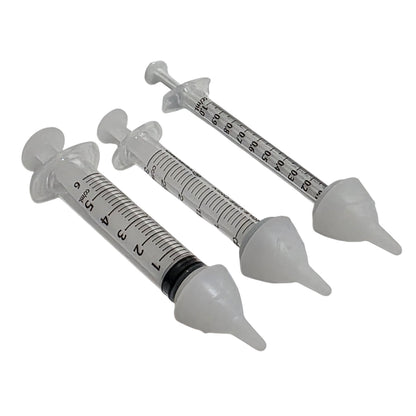 Three clear plastic syringes with SuckleSoft Teats arranged diagonally on a white background.