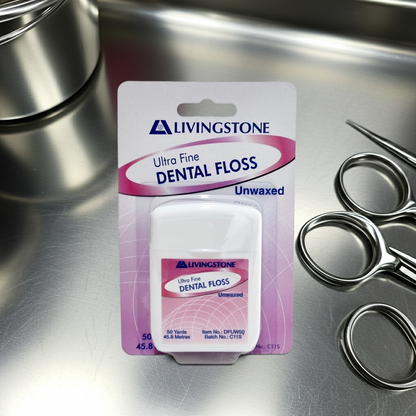 A package of Livingstone Ultra Fine Dental Floss, Unwaxed, displayed on a stainless steel surface next to dental scissors.