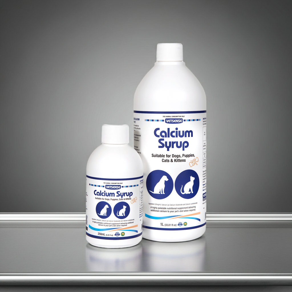 Two bottles of Calcium Syrup for pets on a stainless steel surface with a gray background
