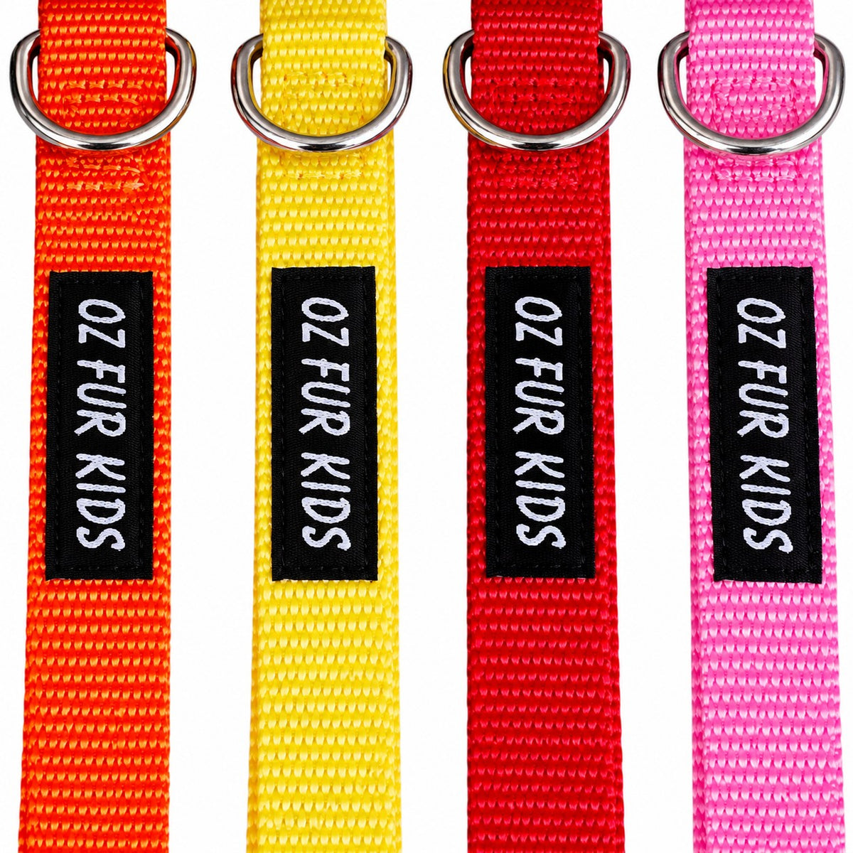 Four colorful woven pet collars in orange, yellow, red, and pink, each with a black label reading 'OZ FUR KIDS' and a silver metal ring at the top, shown on a white background.