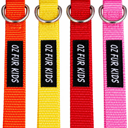 Four colorful woven pet collars in orange, yellow, red, and pink, each with a black label reading 'OZ FUR KIDS' and a silver metal ring at the top, shown on a white background.