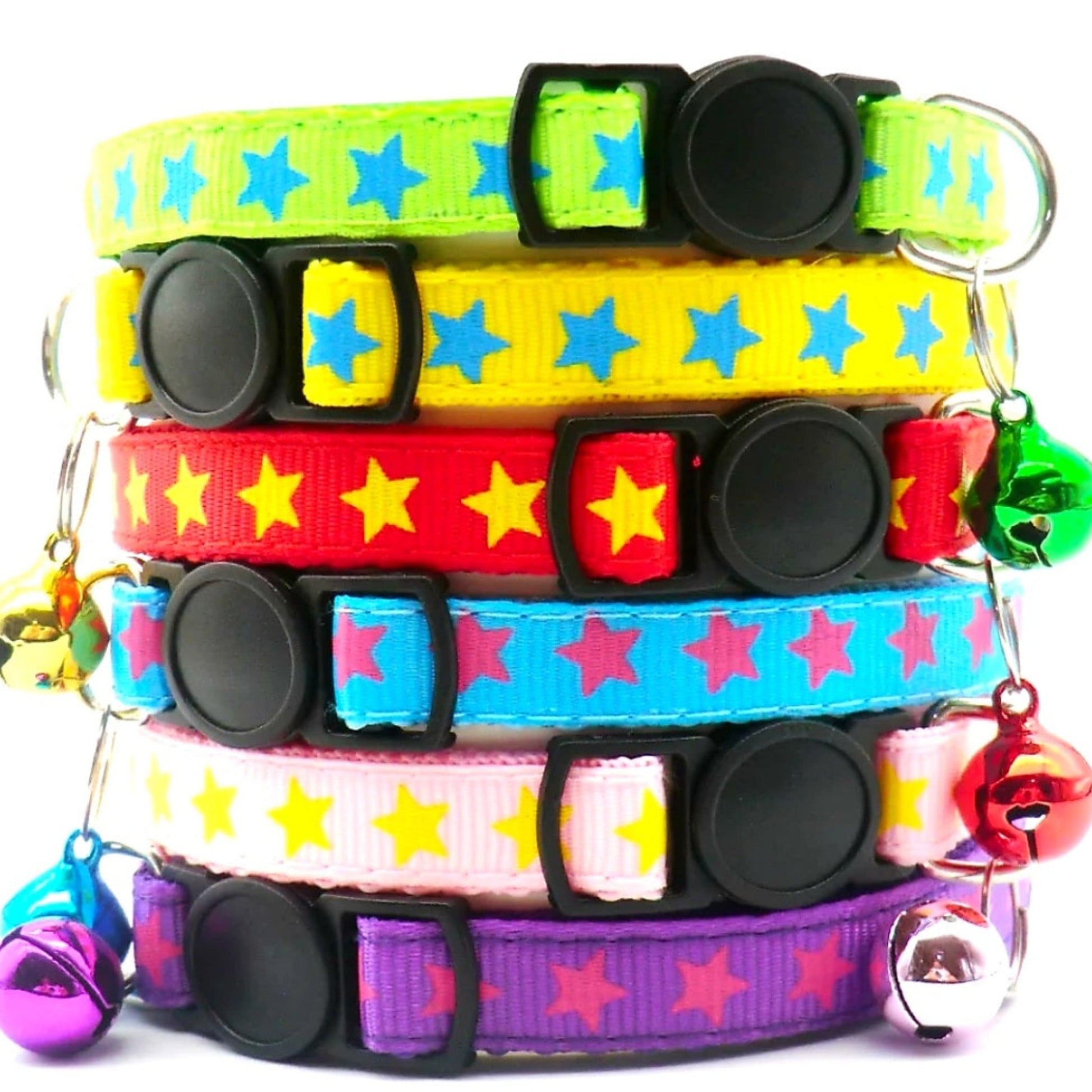 Stack of colorful collars with star patterns and bell charms on a white background